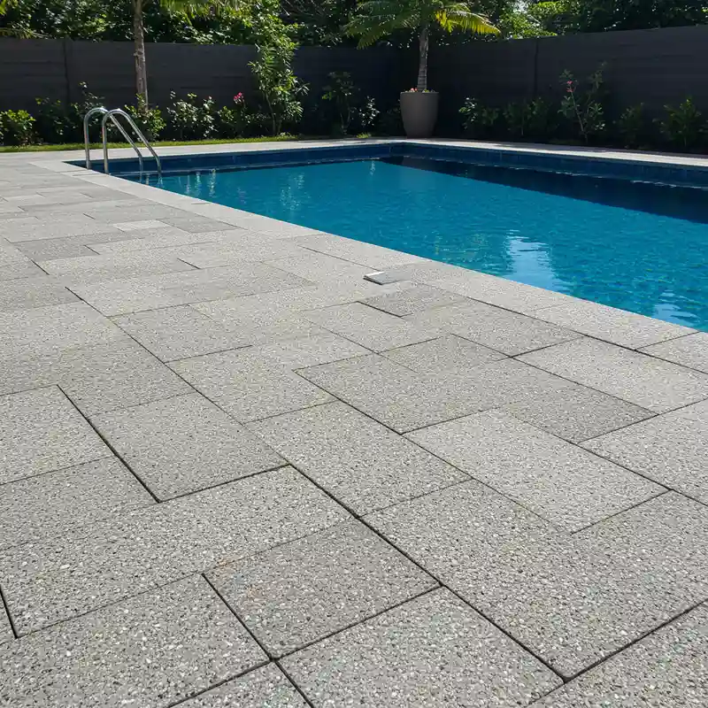 Contour de piscine aménagé avec des dalles gravillonnées 50x50 cm antidérapantes